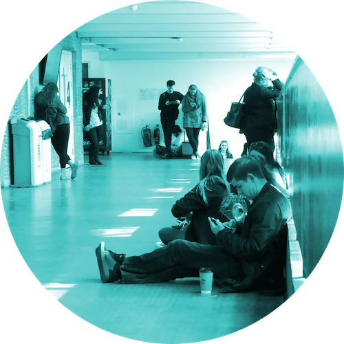 Students in corridor looking at smartphones
